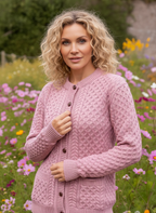 Woman wearing a pink knitted cardigan in a field of flowers