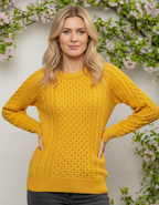 Woman wearing a yellow aran sweater with a floral background