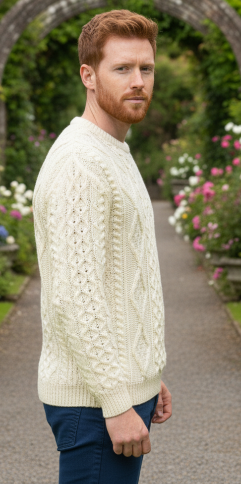 Man in a white sweater standing in a garden with floral arches